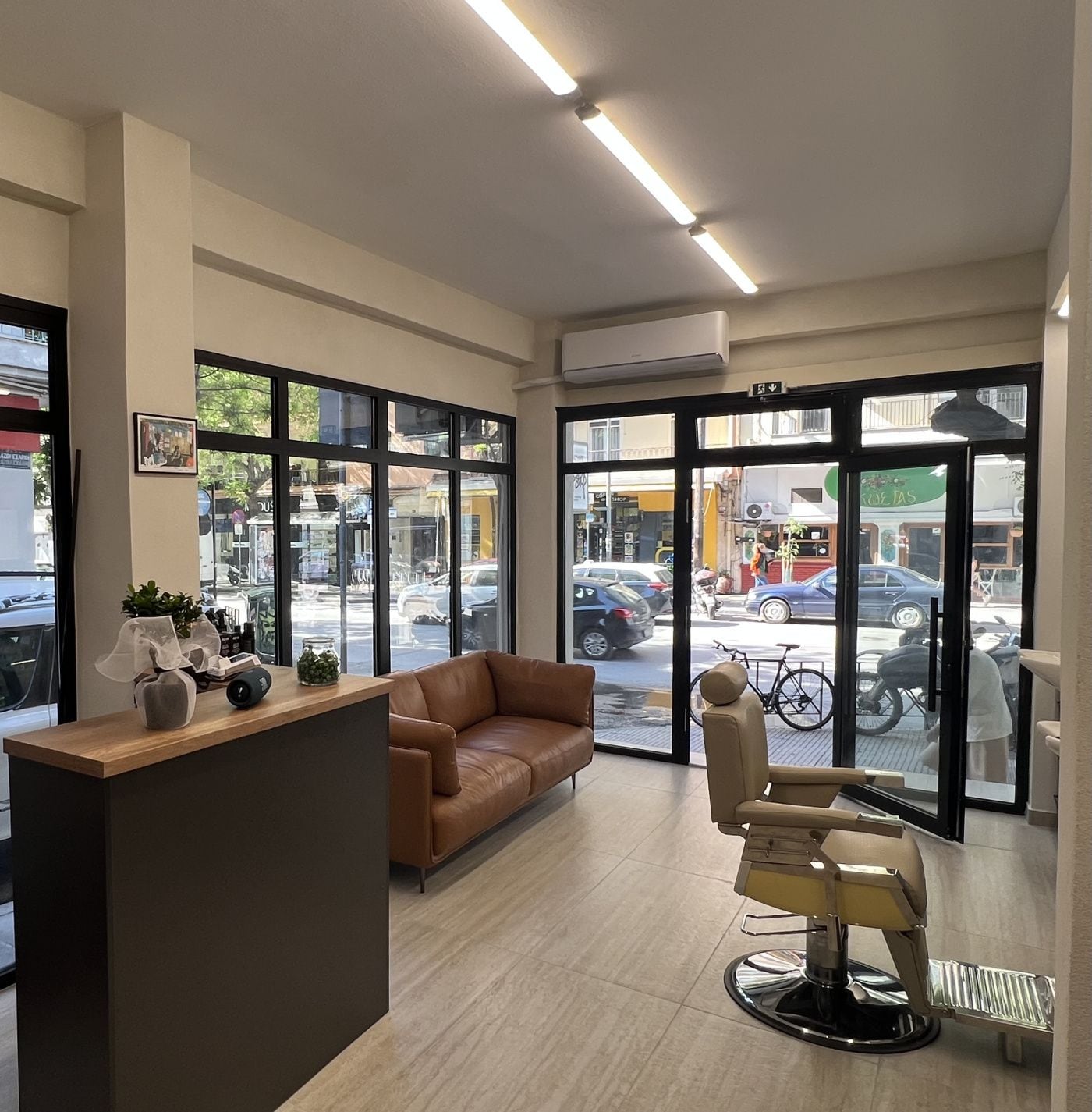 Οι θέσεις εργασίας του ELITE CHOP SHOP με τις μαύρες καρέκλες, τους καθρέφτες και το εξαγωνικό φως στο ταβάνι